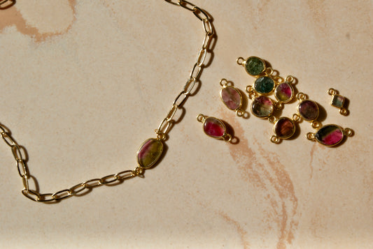 Tourmalines, loose watermelon tourmalines and colourful stones. Watermelon tourmaline on golden chain necklace