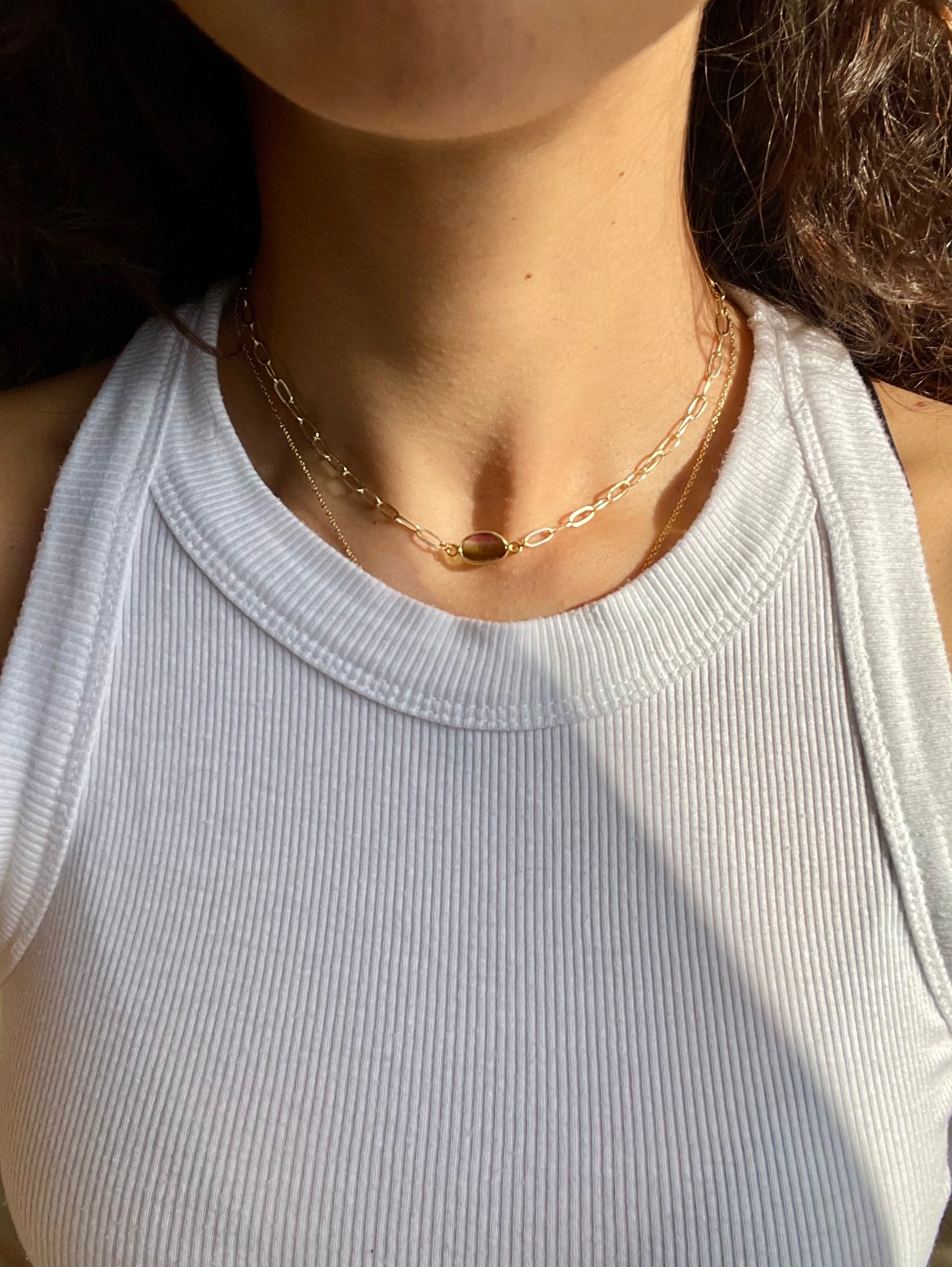 Gold chain with a tourmaline stone on a model